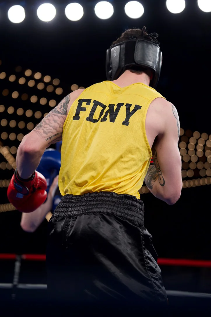 An FDNY boxer in a yellow vest heading to the ring at Battle of the Badges